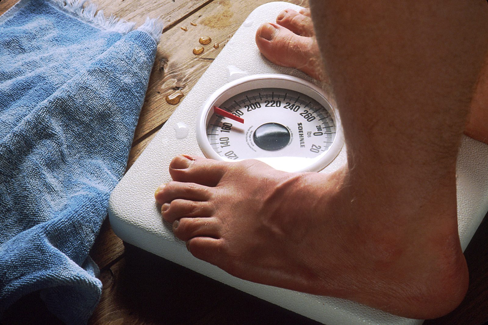 A pair of bare feet standing on a bathroom scale