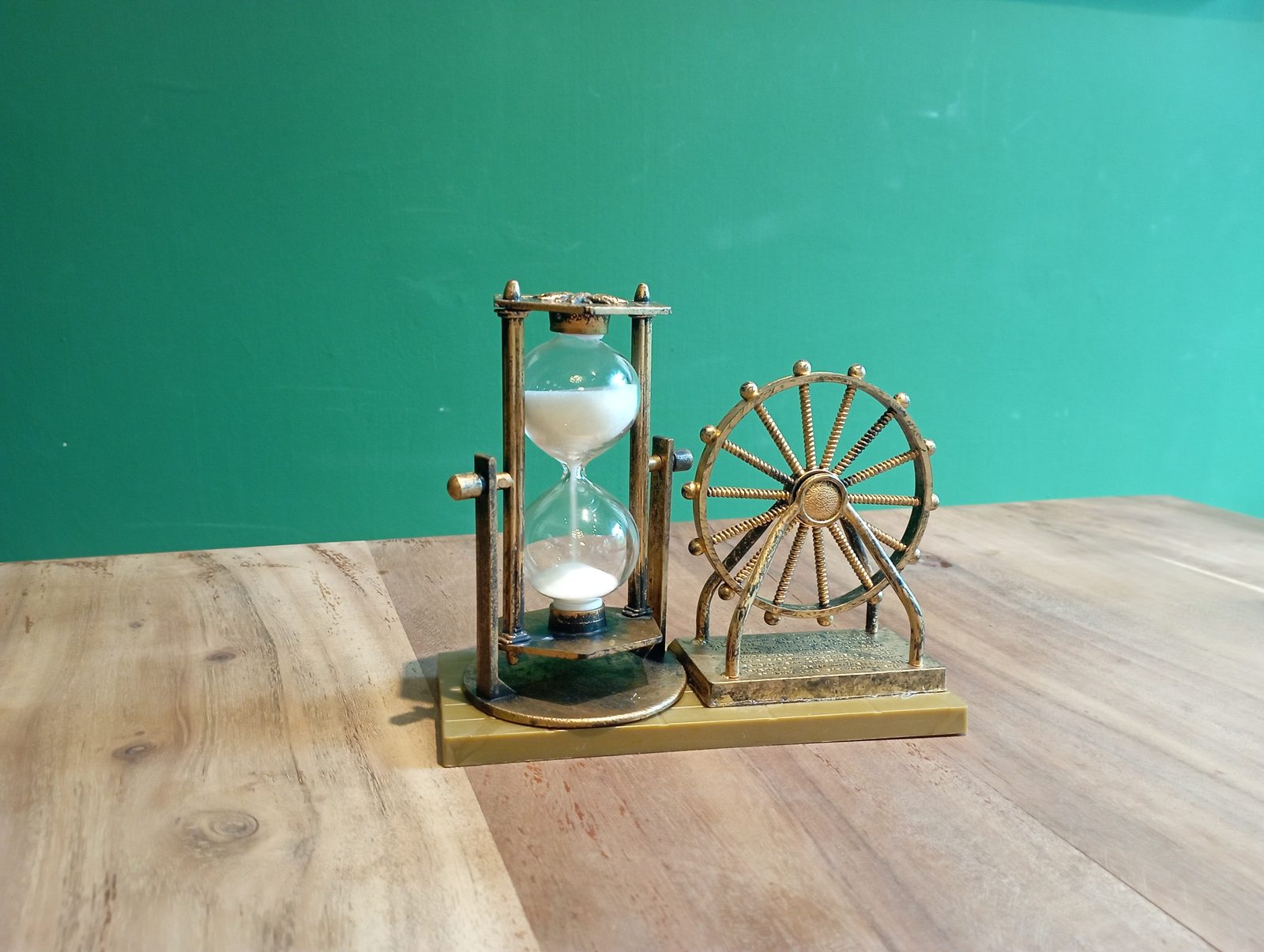 A glass hourglass with sand flowing through it against a plain background